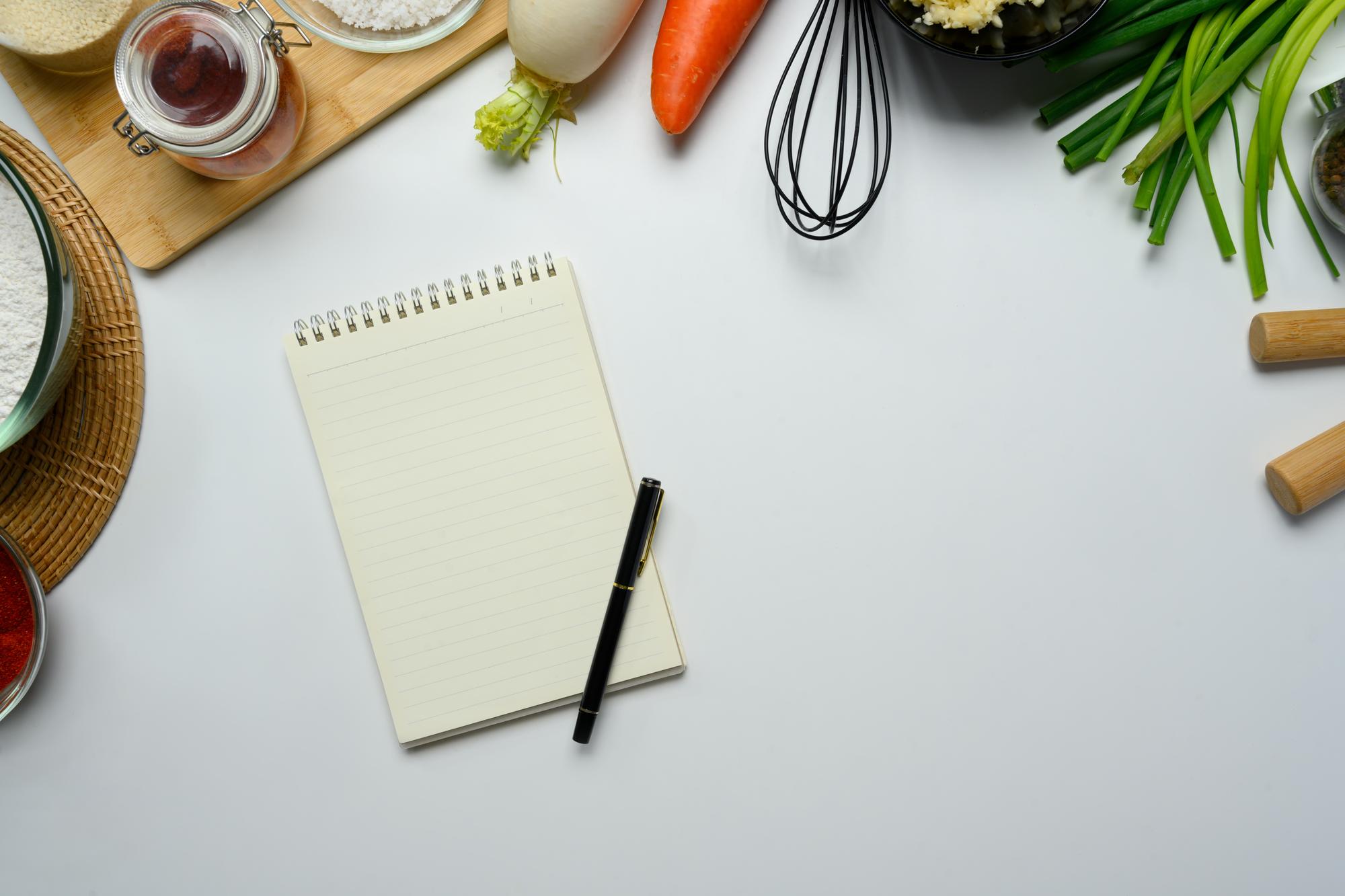 mesa con ingredientes frescos y cuaderno de recetas